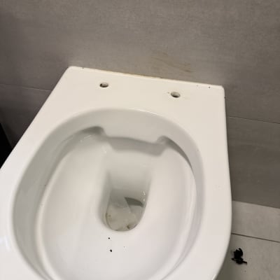אסלה לבנה עם לכלוך קל על הרצפה