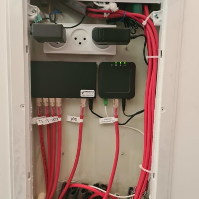 ארון תקשורת עם כבלים אדומים ומתגים