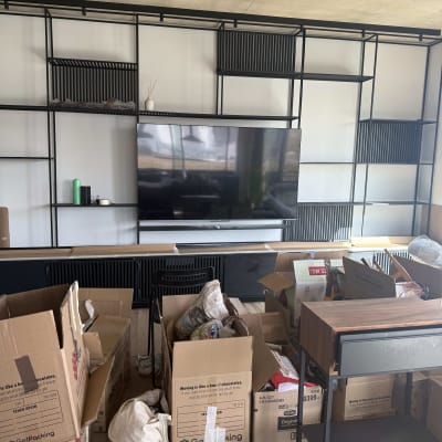 מדפים עם טלוויזיה וארגזים בחדר מגורים