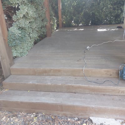 מקדחה חשמלית מונחת על דק עץ עם כבל חשמל