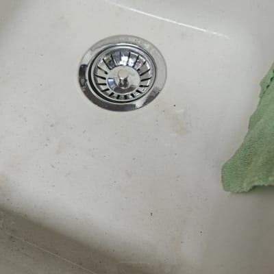 כיור עם ניקוז מתכת ומטלית ירוקה