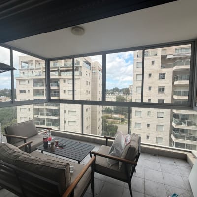 מרפסת עם חלונות אלומיניום ונוף לבניינים סמוכים