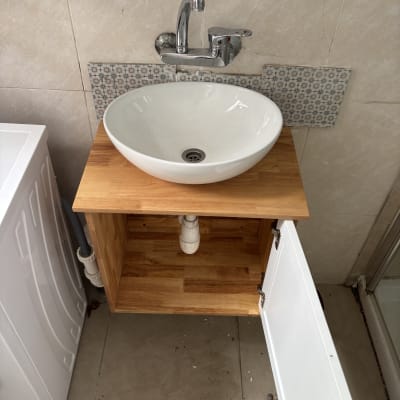 כיור עגול עם ברז על ארון עץ פתוח