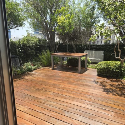 דק עץ עם שולחן בגינה ירוקה