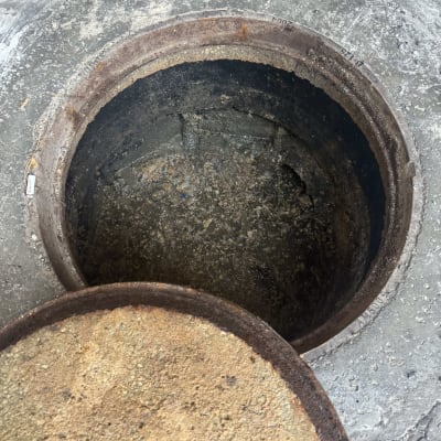 פתח ביוב עגול עם מכסה ברזל חלוד