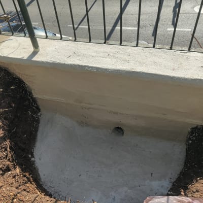 קיר אטום עם חור ניקוז ליד כביש