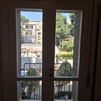 דלת זכוכית עם נוף חיצוני של בניינים ועצים