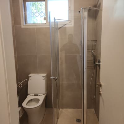 מקלחת ושירותים עם דלת זכוכית ומקלחת גשם