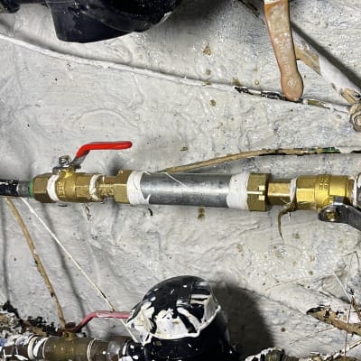 צינורות מתכת עם ברזים אדומים על קיר.