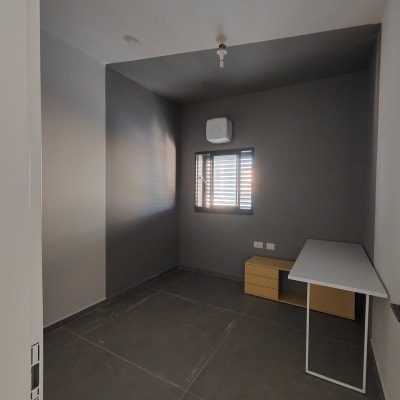 חדר עם קירות אפורים ושולחן לבן