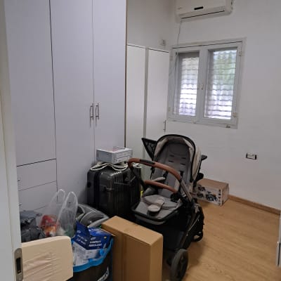 חדר עם ארון, עגלת תינוק וארגזים לאריזה וסידור