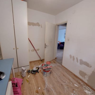 חדר עם כלי עבודה, דלי צבע ומברשת על הרצפה