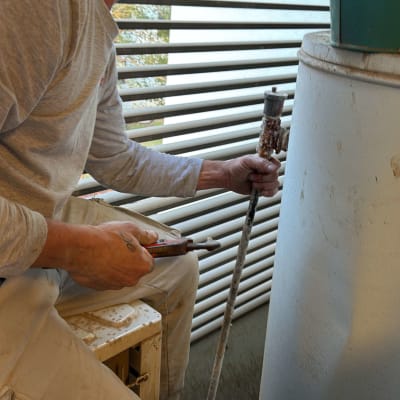 אדם עובד על דוד שמש עם כלי עבודה