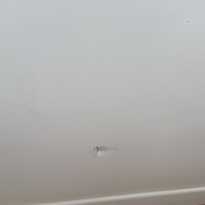 קיר עם חור קטן ושריטות, רצפת עץ למטה