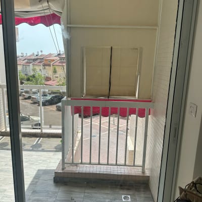 מרפסת עם דלת זכוכית ומעקה לבן