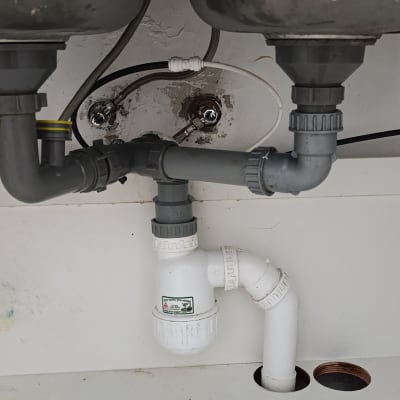 צנרת מתחת לכיור עם חיבורים ואביזרים