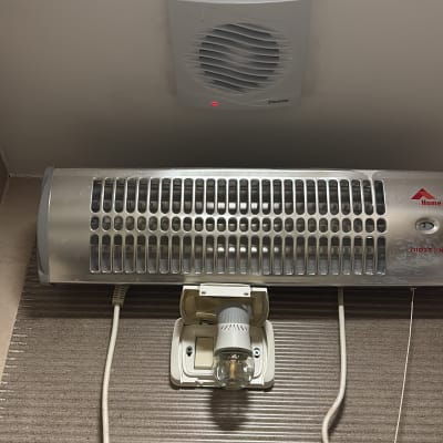 תנור חימום ומאוורר על קיר בחדר אמבטיה