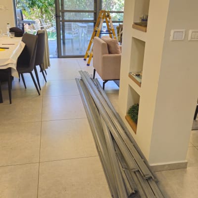 חדר עם תריסים וחלקי מתכת על הרצפה