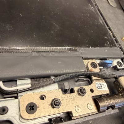 חלקי מחשב נייד עם ברגים וחיבורים פנימיים