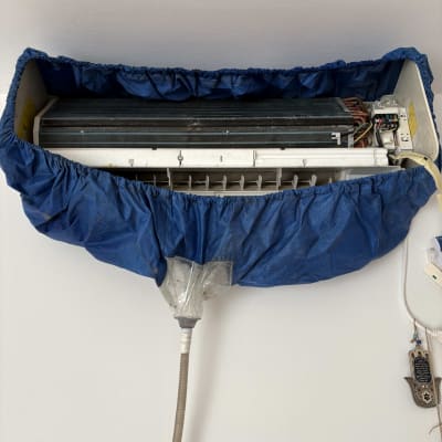 מזגן עם כיסוי כחול מותקן על קיר