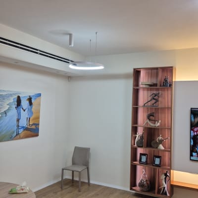 חדר עם תאורה מודרנית וארון מדפים מעוצב