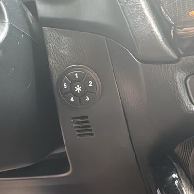 כפתור התנעה ברכב עם נעל לבנה