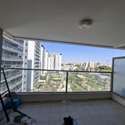 מרפסת עם נוף לעיר, סולם וכלים על הרצפה