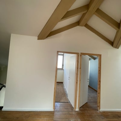 קירות גבס לבנים עם דלתות עץ פתוחות