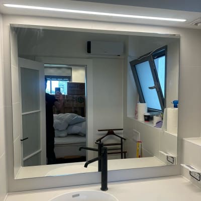 מראה גדולה מעל כיור בחדר אמבטיה