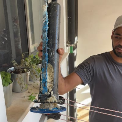 אדם מחזיק רכיב סולארי עם הצטברות אבנית