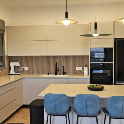 מטבח מודרני עם אי, כיסאות, כיור ותנור