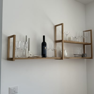 מדף עץ תלוי עם כוסות יין ובקבוק