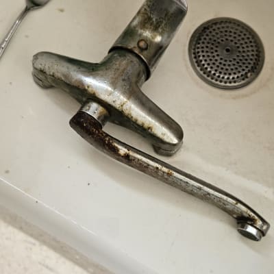 ברז חלוד מונח בכיור לבן