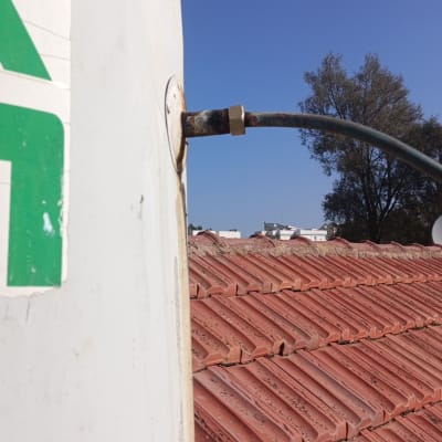 דוד שמש על גג רעפים אדומים עם צינור מחובר