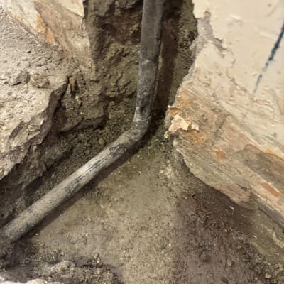 צינור חשוף בקיר עם סימני נזילה