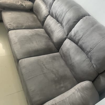 ספה אפורה בחדר מואר עם כריות