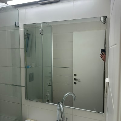 מראה וכיור בחדר אמבטיה עם ברז זכוכית