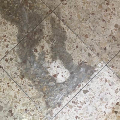 רצפה מלוכלכת עם כתם כהה על אריחים