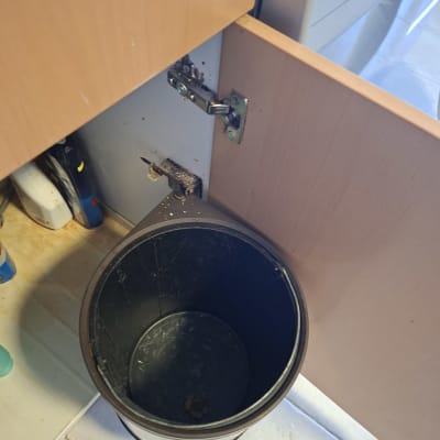 פח אשפה מתחת לכיור עם דלת פתוחה
