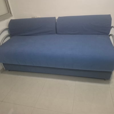 ספה כחולה בחדר עם רצפת קרמיקה