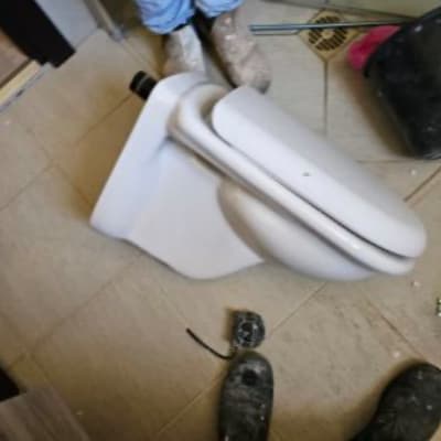 אסלה מונחת על הרצפה עם כלי עבודה מסביב