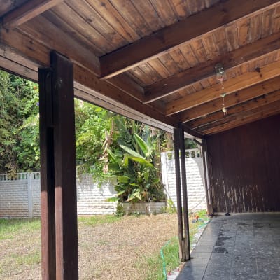 פרגולה מעץ עם גינה קטנה ודשא יבש