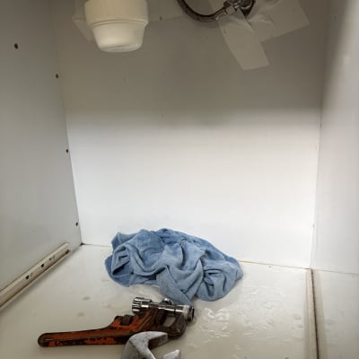 כלי עבודה וצינור מתחת לכיור