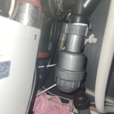 צנרת מתחת לכיור עם מגבת ורודה