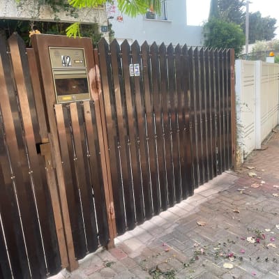 שער חשמלי חום עם תיבת דואר ומספר בית 42