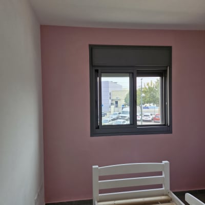 קיר צבוע בצבע ורוד ליד חלון