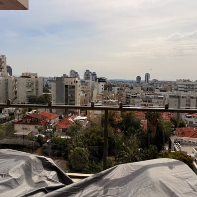 מעקה זכוכית במרפסת עם נוף לעיר