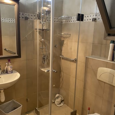 מקלחון זכוכית עם ראש מקלחת בחדר אמבטיה