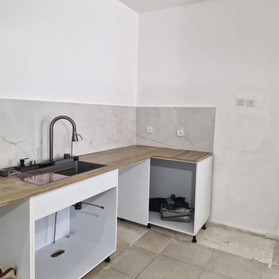 מטבח בשיפוץ עם ארונות פתוחים וכיור מותקן