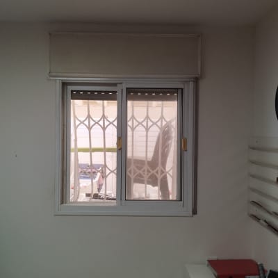 חלון עם תריסים סגורים ומסגרת לבנה